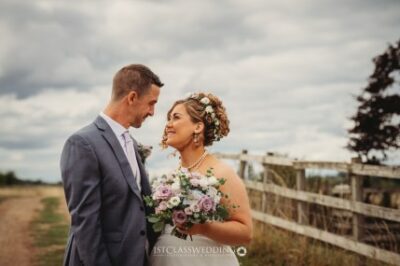 Couple embracing at rustic outdoor wedding.