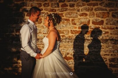 Couple holding hands at sunset wedding