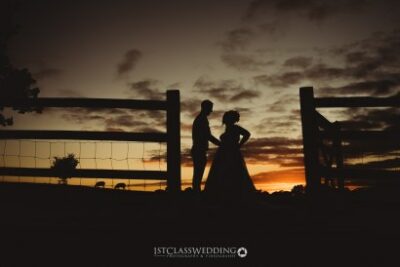 Silhouetted couple at sunset, wedding photography.