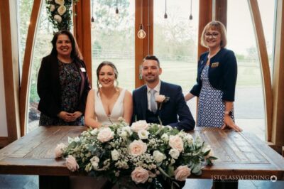 Wedding couple with registrars and floral arrangement.