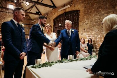 Wedding ceremony handshake in rustic venue