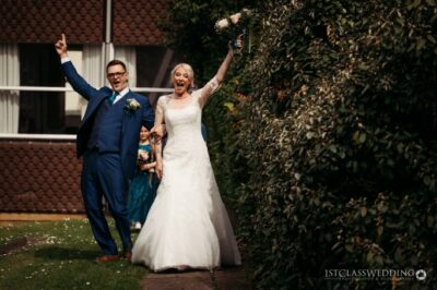 Exuberant bride and groom celebrating outdoors.