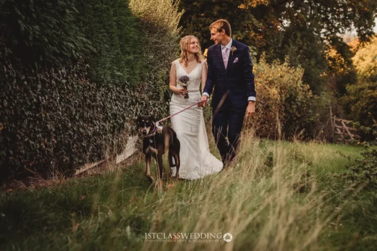 Couple with dog walking after wedding ceremony.