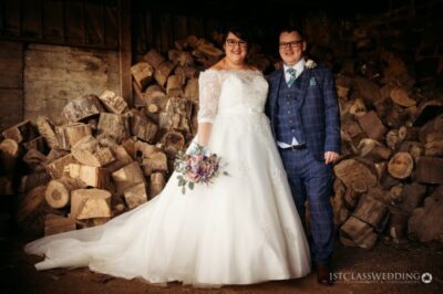 Bride and groom posing with firewood background.