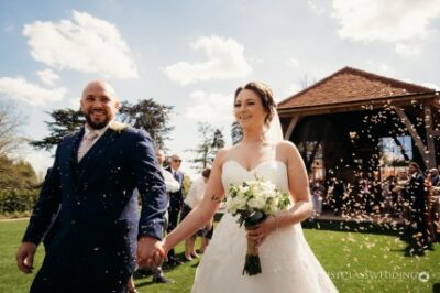 Joyful newlyweds with confetti at outdoor wedding