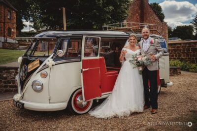 Bride and groom posing with vintage Volkswagen van.