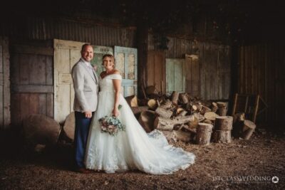 Bride and groom smiling in rustic barn setting.