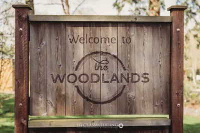 Rustic 'Welcome to the Woodlands' sign.