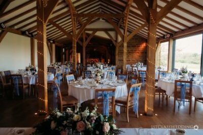 Elegant barn wedding reception setup with floral decorations.