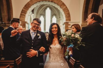 Bride and groom smiling in church after wedding ceremony.