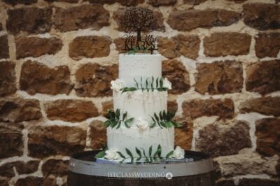 Three-tier wedding cake with floral decoration on barrel
