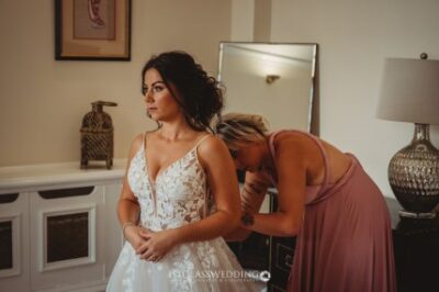 Bride getting ready with bridesmaid's assistance.