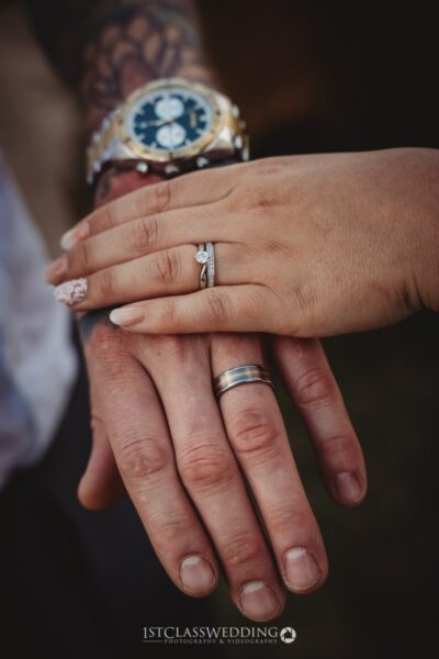Close-up of couple's hands with wedding rings.