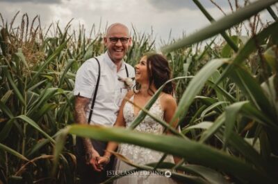 Happy couple laughing in cornfield.