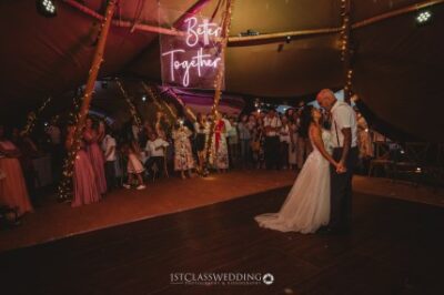Couple's first dance at wedding under "Better Together" sign.
