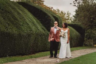Couple in wedding attire walking in garden