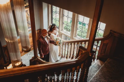 Wedding couple posing on elegant staircase.