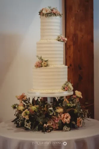 Elegant tiered wedding cake with floral decorations.