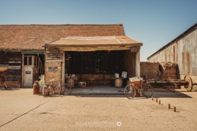 Rustic barn exterior with vintage bicycles and farm tools.
