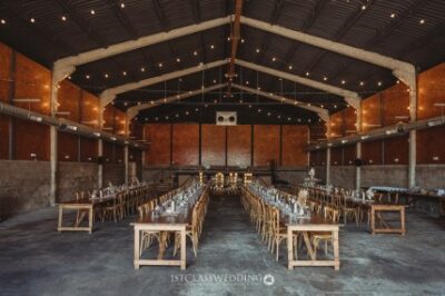 Rustic barn wedding venue with set tables and lighting