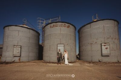 Couple posing at industrial silo wedding venue.
