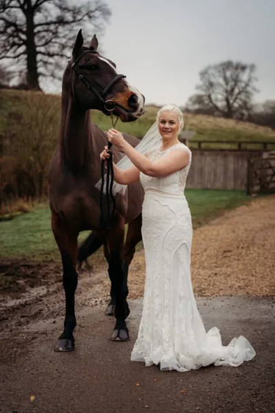 Bride with horse in countryside wedding scene.