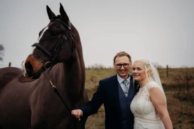 Bride, groom, and horse outdoors at wedding