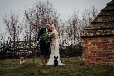 Couple with dogs at countryside wedding.