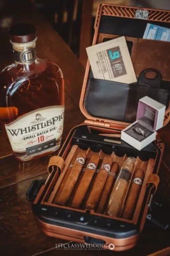 WhistlePig whiskey, cigars in case, and wedding band.
