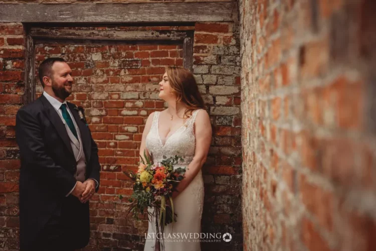 Couple smiling at each other in alleyway wedding photo.