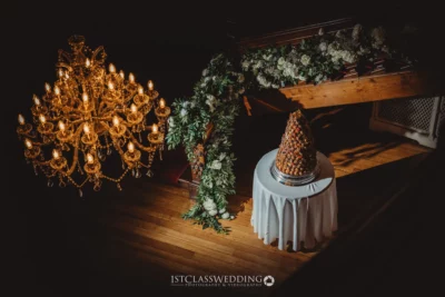 Elegant chandelier above wedding croquembouche table.