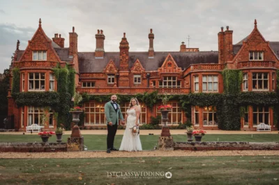 Couple posing at elegant brick manor wedding venue.