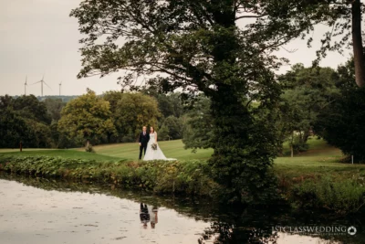 Couple by lake at golf course wedding.