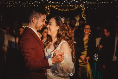 Couple's first dance with fairy lights background.