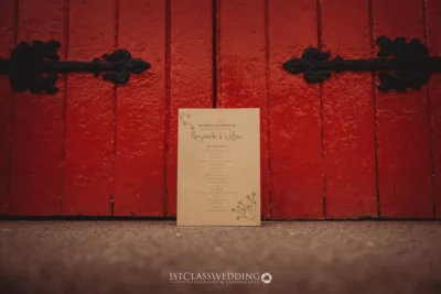 Wedding invitation on red wooden door background.