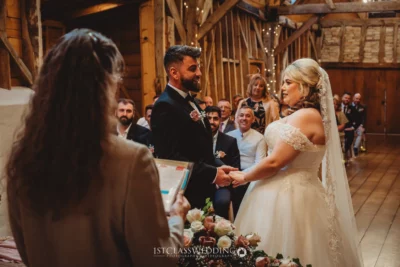 Bride and groom exchanging vows at rustic wedding