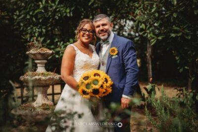 Bride and groom with sunflower bouquet at garden wedding.