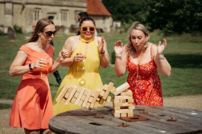 Three women playing giant Jenga outdoors at event