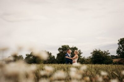 Couple embracing in a field with flowers.