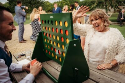 Woman celebrating victory in outdoor Connect Four game.