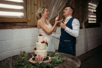 Bride and groom cutting wedding cake together.