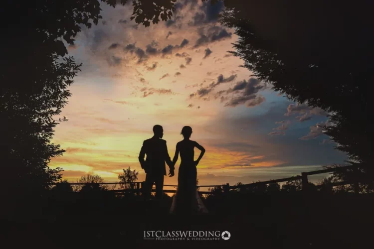Silhouetted couple at sunset, wedding photography.