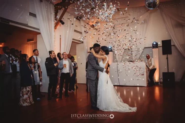 Couple kissing during wedding confetti toss celebration
