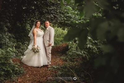 Bride and groom posing in woodland setting