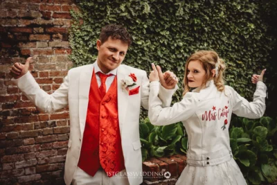 Bride and groom playfully posing with thumbs up.