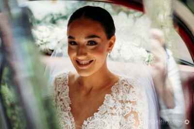 Bride smiling in car on wedding day