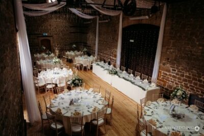 Elegant wedding reception hall with decorated tables.