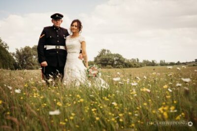 Military groom and bride in flower field.