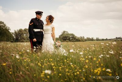 Couple in wedding attire in blooming meadow.