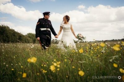 Bride and groom holding hands in flowery field